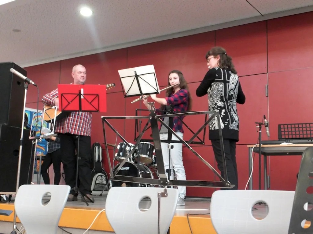 Zwei Personen musizieren an Mikrofonen auf der Bühne.